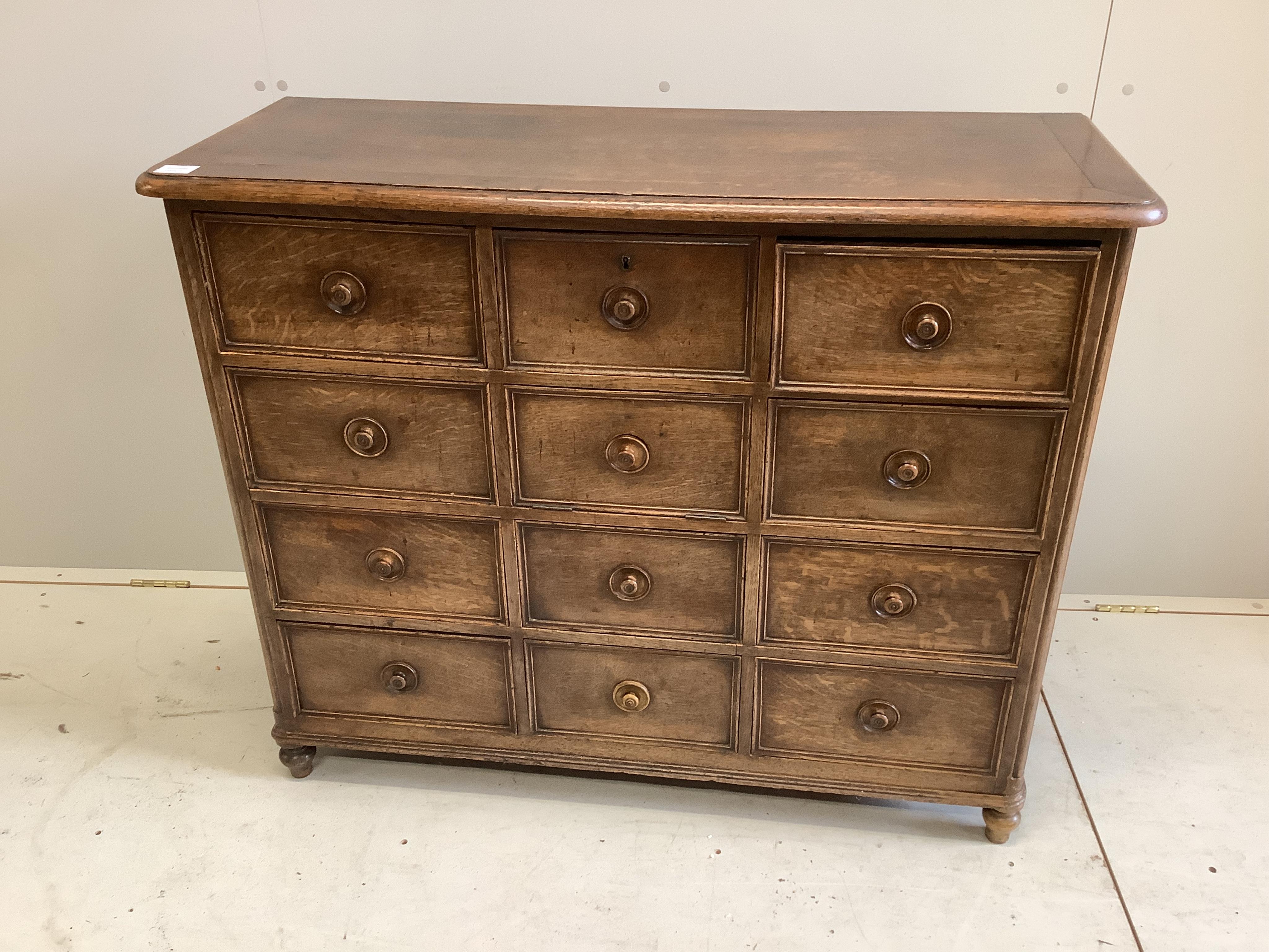 A 19th century French oak chest with central fall front door surrounded by eleven short drawers, width 110cm, height 91cm. Condition - fair to good